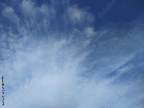 Ant's eye view of white clouds moving with blue sky background.