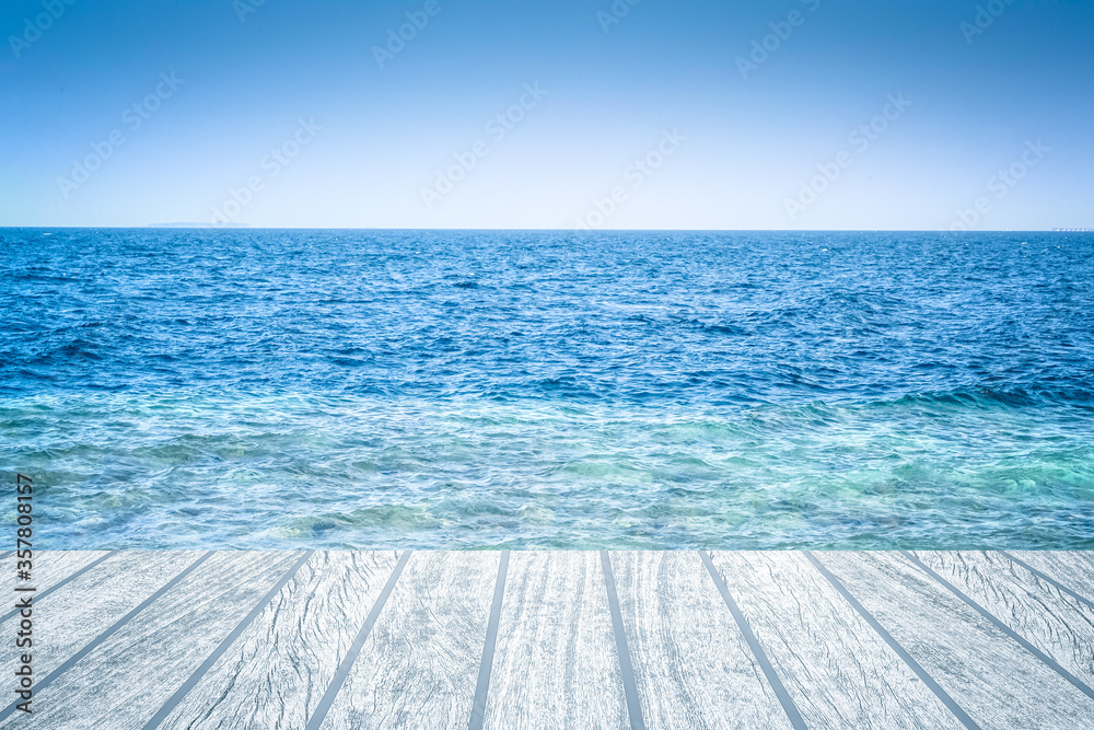 Wood table top over summer sea and blue sky with white clouds background. Montage style to dispaly the product