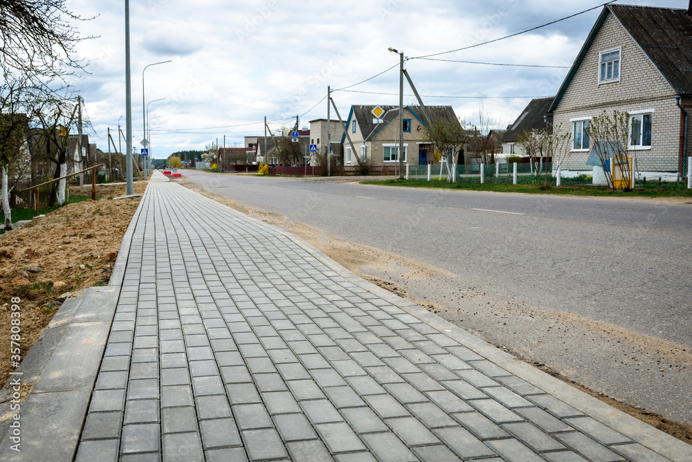 Empty walking path near road and apartment houses.