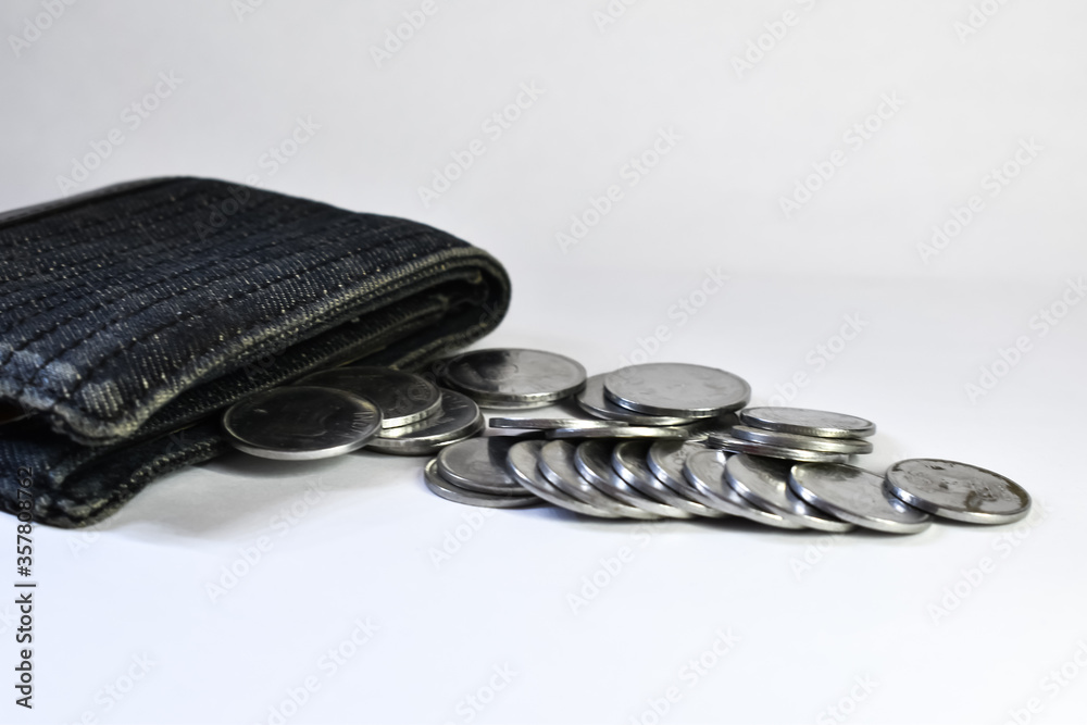 Black denim wallet with brass indian coins on white background. Artistic blur effect applied. Black denim wallet with brass indian coins on white background. Artistic blur effect applied.