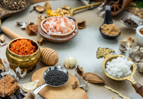 Fototapeta Naklejka Na Ścianę i Meble -  Various spices and herbs in rustic style with honey on balck background. Natural herbs medicine, Organic herbal and healthy concept, Selective focus.