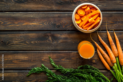 Carrot slices, fresh juice, vegetable with green tops top view copy space