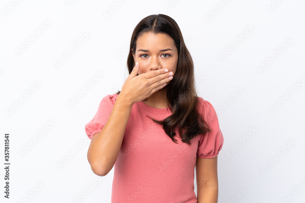 Young Colombian girl over isolated white background covering mouth with hands Young Colombian girl over isolated white background covering mouth with hands