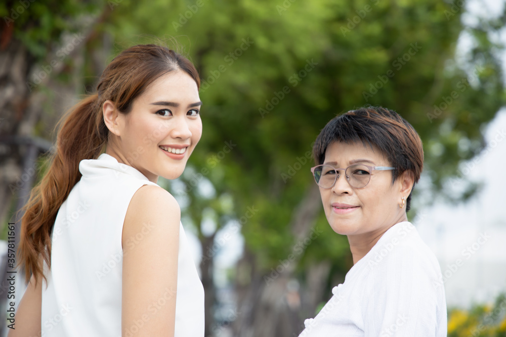 portrait of happy senior mother and adult daughter looking back over shoulder, happy family concept portrait of happy senior mother and adult daughter looking back over shoulder, happy family concept