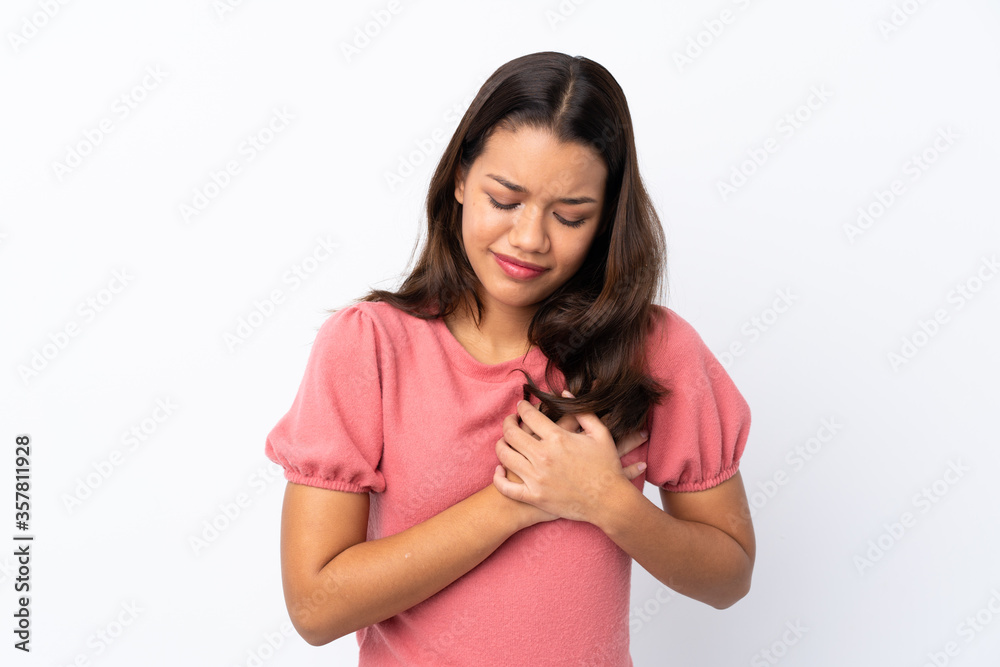 Young Colombian girl over isolated white background having a pain in the heart Young Colombian girl over isolated white background having a pain in the heart