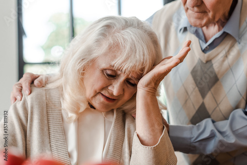 elderly wife having headache at home with husband during self isolation