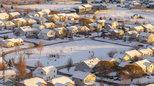 Panorama Aerial view of homes in snowy Utah Valley neighborhood at sunset in winter