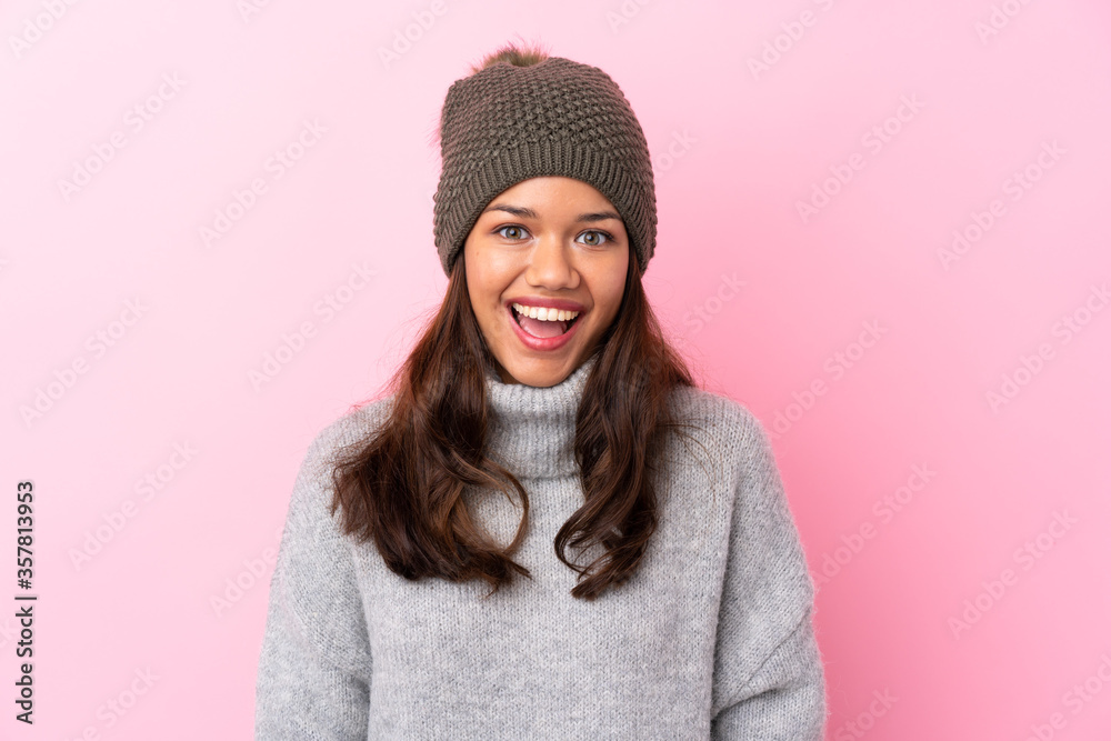 Young Colombian girl with winter hat over isolated pink wall with surprise facial expression Young Colombian girl with winter hat over isolated pink wall with surprise facial expression