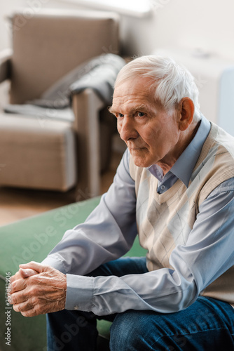 lonely elderly man sitting on sofa during quarantine