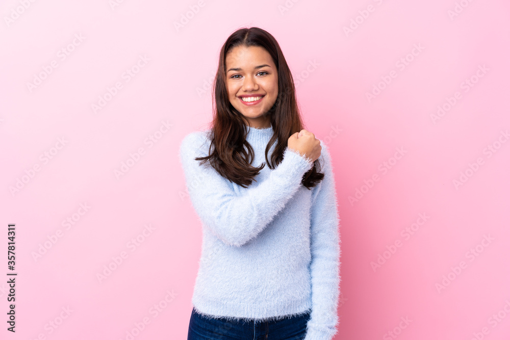 Fototapeta premium Young Colombian girl over isolated pink background celebrating a victory