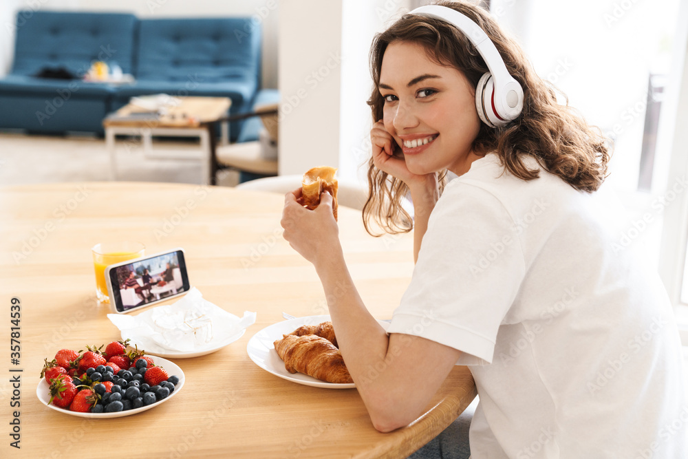Photo of woman watching movie on mobile phone while having breakfast Photo of woman watching movie on mobile phone while having breakfast
