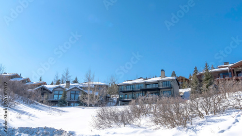 Panorama Houses on snowy hill terrain in Park City Utah with clear blue sky background