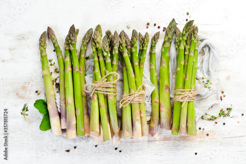 Fresh green asparagus on a white wooden background. Healthy food. Top view, free copy space.