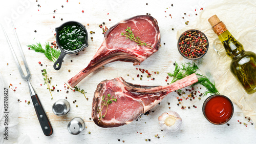 Dry aged raw tomahawk beef steak. Steak on the bone. On a white wooden background. Top view. Free copy space.