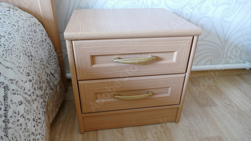 there is a nightstand next to the bed