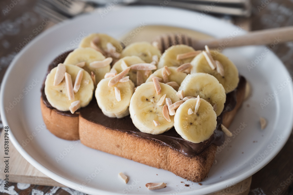 toasted bread topped with chocolate, banana, sliced almond and honey