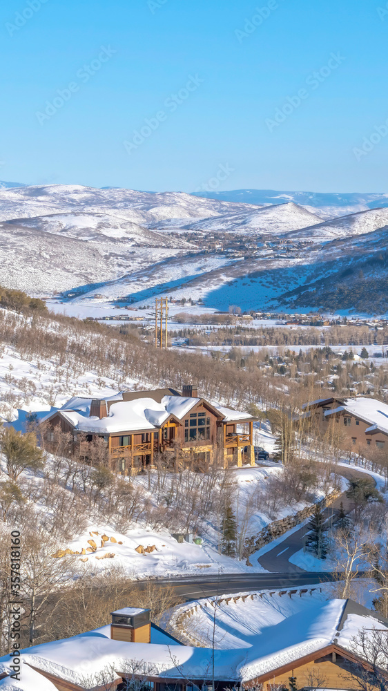 Vertical crop Luxurious homes in Park City on mountain landscape blanketed with snow in winter