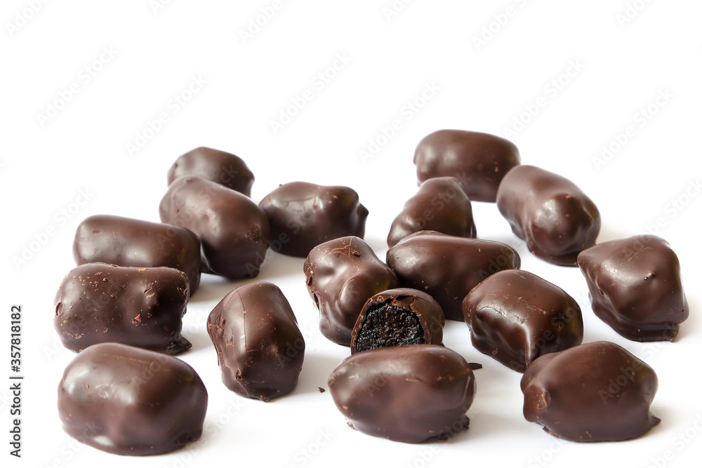 Chocolate candies in bulk on a white background. Dark chocolates with natural plum filling Chocolate candies in bulk on a white background. Dark chocolates with natural plum filling
