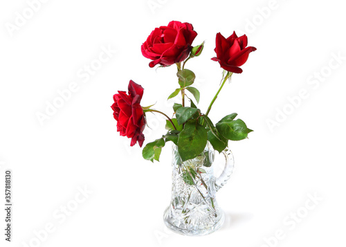 Three red fresh luxurious roses in a crystal vase. Isolated on white. With shadow. Copy space