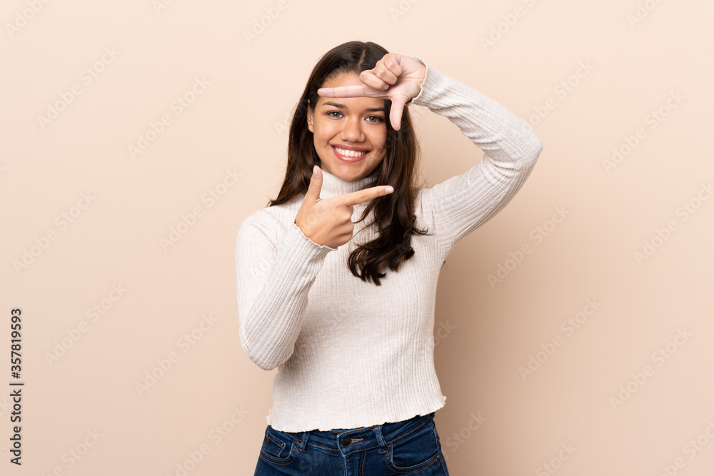 Young Colombian girl over isolated background focusing face. Framing symbol Young Colombian girl over isolated background focusing face. Framing symbol