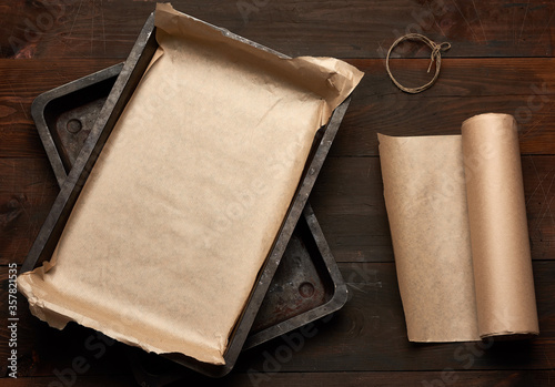 empty rectangular metal pan covered with brown parchment paper and paper rolls
