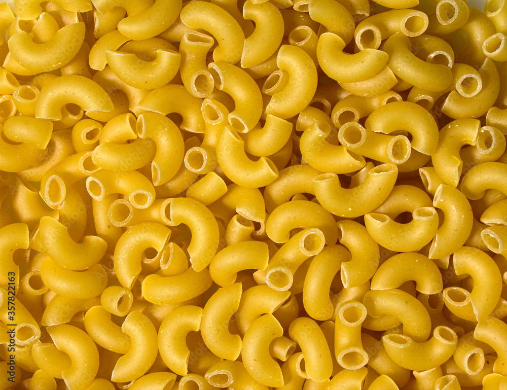 Texture of pasta in the form of an arc. Pasta close-up twisted horns. Raw pasta heart shaped horns. Texture of pasta in the form of an arc. Pasta close-up twisted horns. Raw pasta heart shaped horns.
