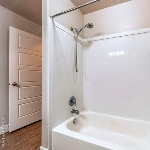 Square frame BAthroom interior with built in bathtub stainless steel shower head and faucet