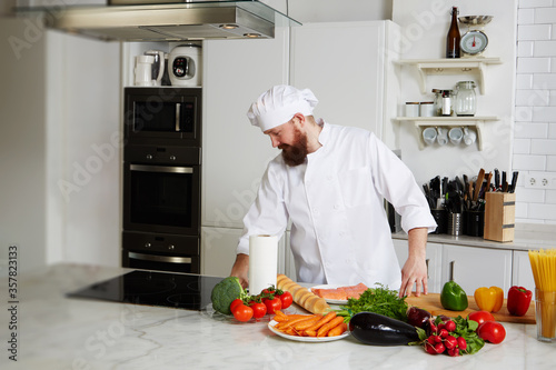 Portrait of mature chef in uniform prepare his kitchen 