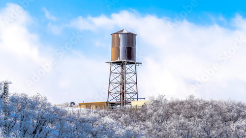 Panorama Water tank storage container on a tower at the snowy slope of Wasatch Mountains