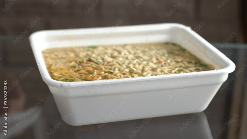 close up man hands opens a container with fast food noodles