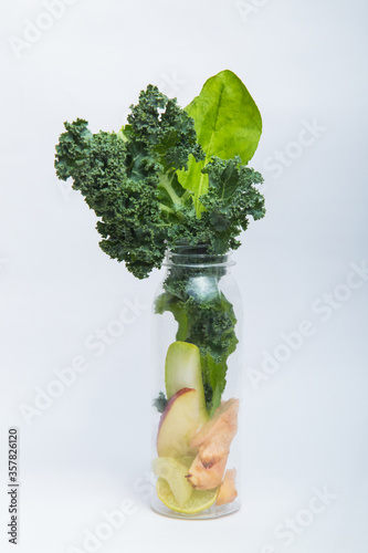 Kale, Spinach, Amla, Celery, Apple, Ginger & Lemon in a Plastic Bottle. Green Vegetable Smoothie Ingredients. Raw, Natural, Organic Healthy Juice. Detox Cleanse Drink Concept. Weight Loss or Dieting.
