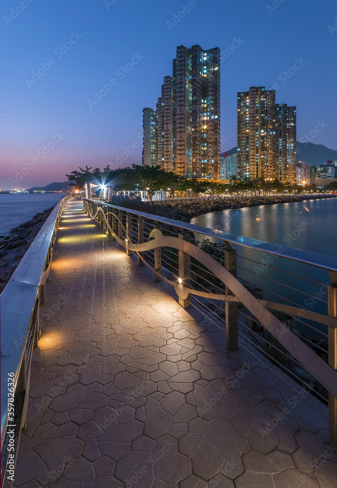 Obraz premium Seaside promenade and high rise residential building in Hong Kong city at night