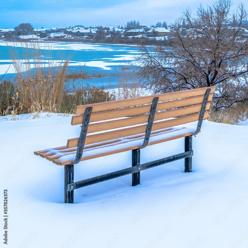 Square crop Bench on a snowy terrain with frozen Utah Lake and overcast sky view in winter