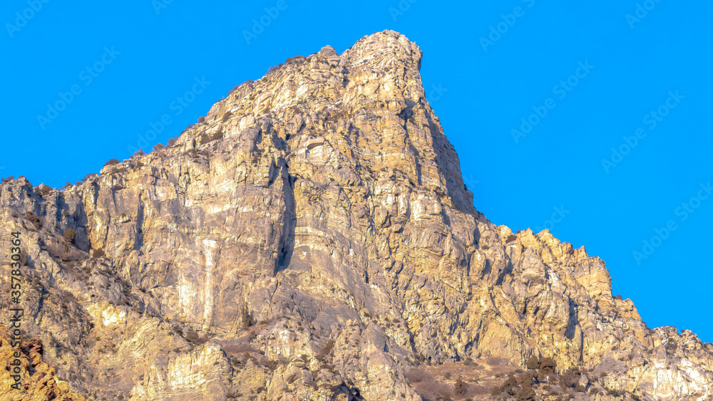 Panorama frame Precipitous slope of a rocky mountain gainst clear blue sky in Provo Canyon