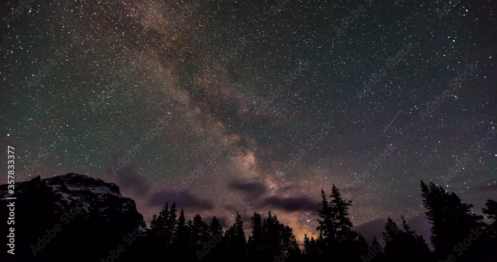 Time lapse shot of Milky Way over mountain and trees against sky at night - Banff, Canada