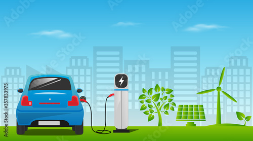 Electric car charging at the charger station. Wind turbine and solar panel with green city skyline in background