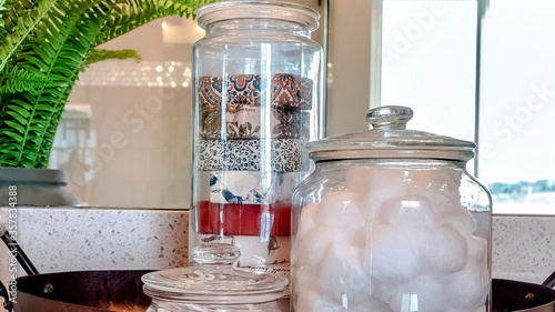 Fotografie Panorama frame Jars of soap cotton balls and buds on metal tray beside potted le