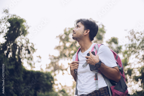 Young Asian man traveling backpacker in the forest, Concept of nature tourism