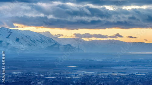 Panorama crop Salt Lake City Utah landscape against snowy mountain and cloudy sky at sunset