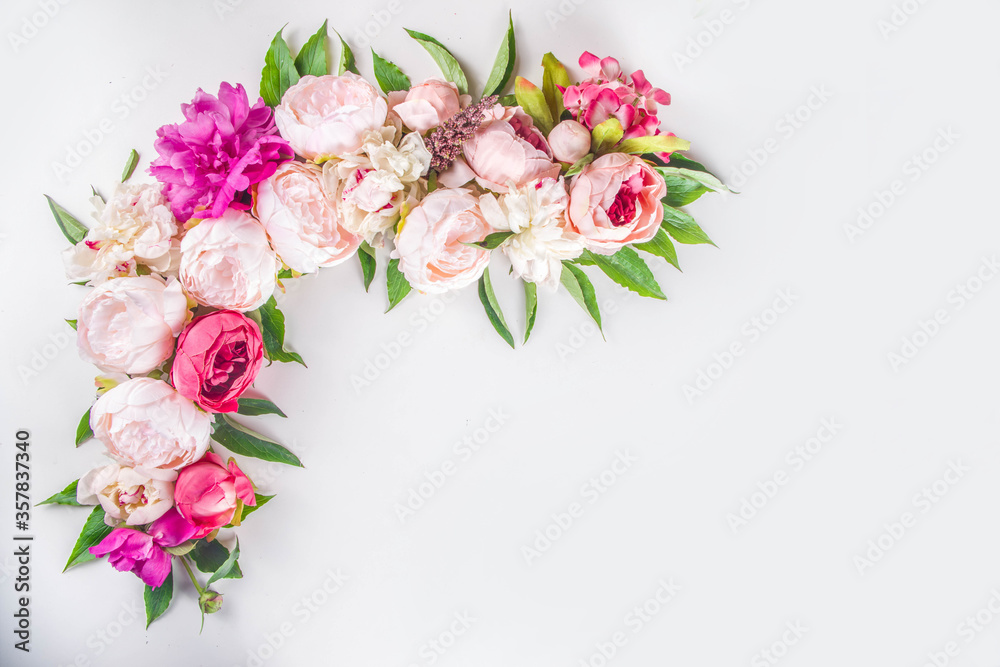 Flat lay of flowers and green leaves. Tender Peonies and chrysanthemums bloom pattern, composition for postcards on white background.