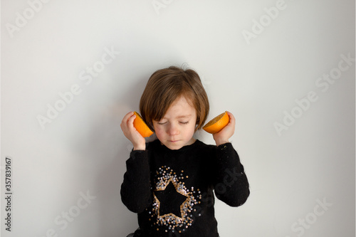 Retrato de una niña con naranjas y jersey negro