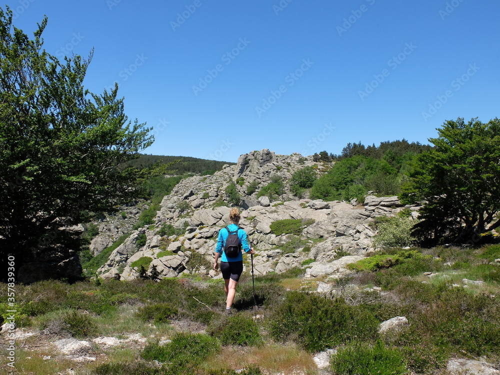 Jeune femme seule avec sac à dos marchant en randonnée trekking dans la montagne du Caroux du Parc naturel Régional du Haut Languedoc