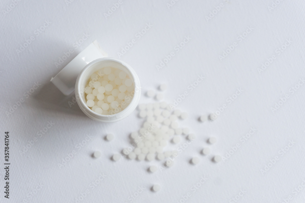 Homeopathy pills in a pot and spread on the surface. Medical concept. Homeopathy pills in a pot and spread on the surface. Medical concept.