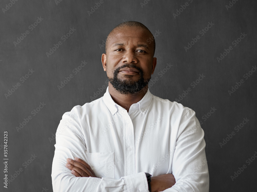 Confident African American businessman standing in front of a chalkboard - obrazy, fototapety, plakaty 