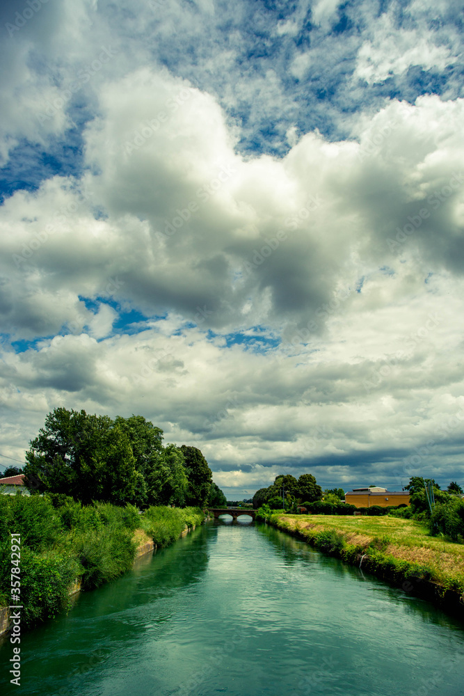 irrigation canal in the countryside dominated by storm clouds