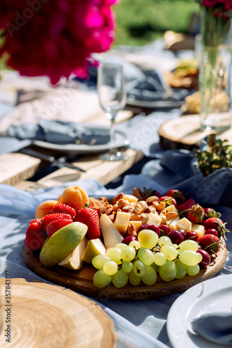 wooden platter with fruit and cheese