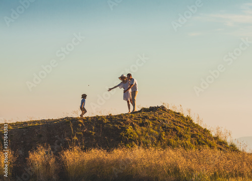 Little boy running up the hill to meet his parents