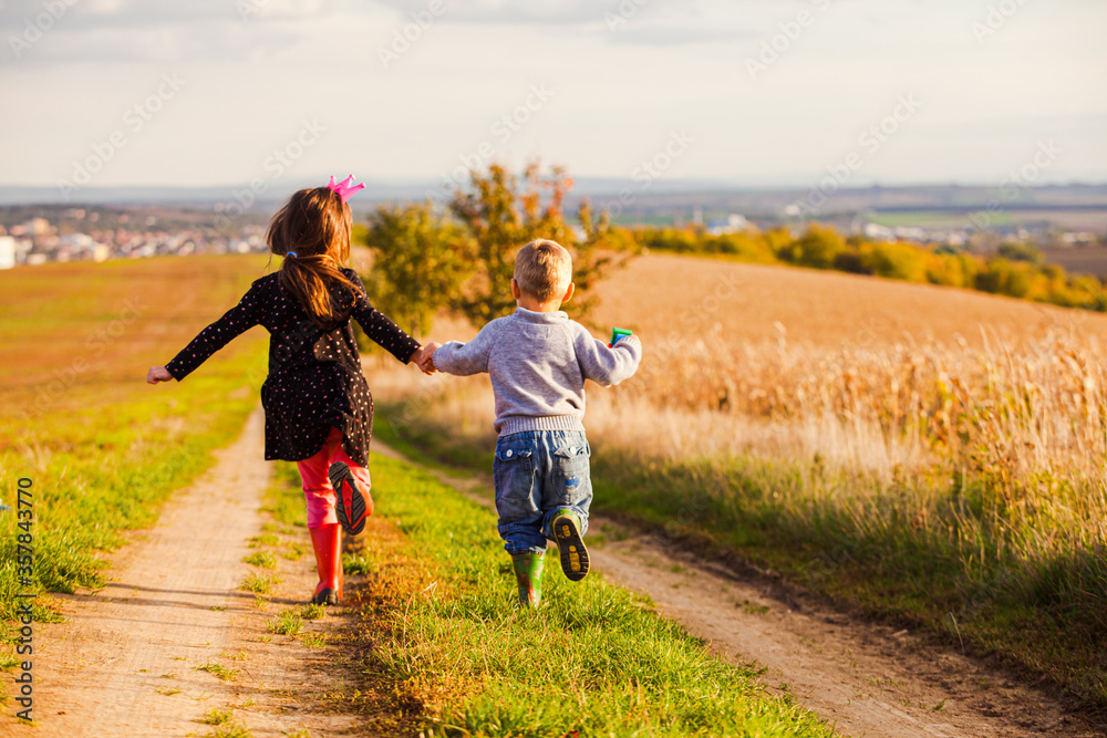 Kids have fun are running on country road Kids have fun are running on country road