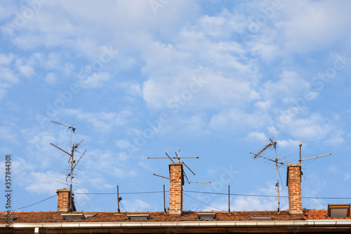 Television antennas, VHF and UHF frequencies, at the top of a European roof. VHF and UHF are two of the main TV transmission and reception systems