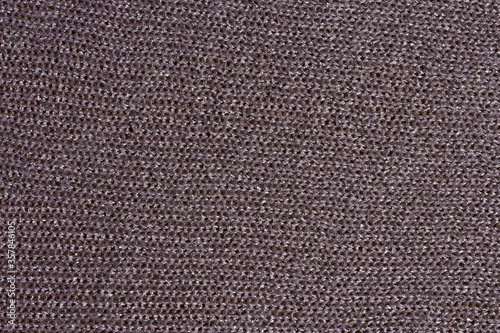 Knitted mauve background. Knitted purple textiles for text. The texture of a wool sweater. Hand knitting. Machine knitting. Purple, violet, lavender.